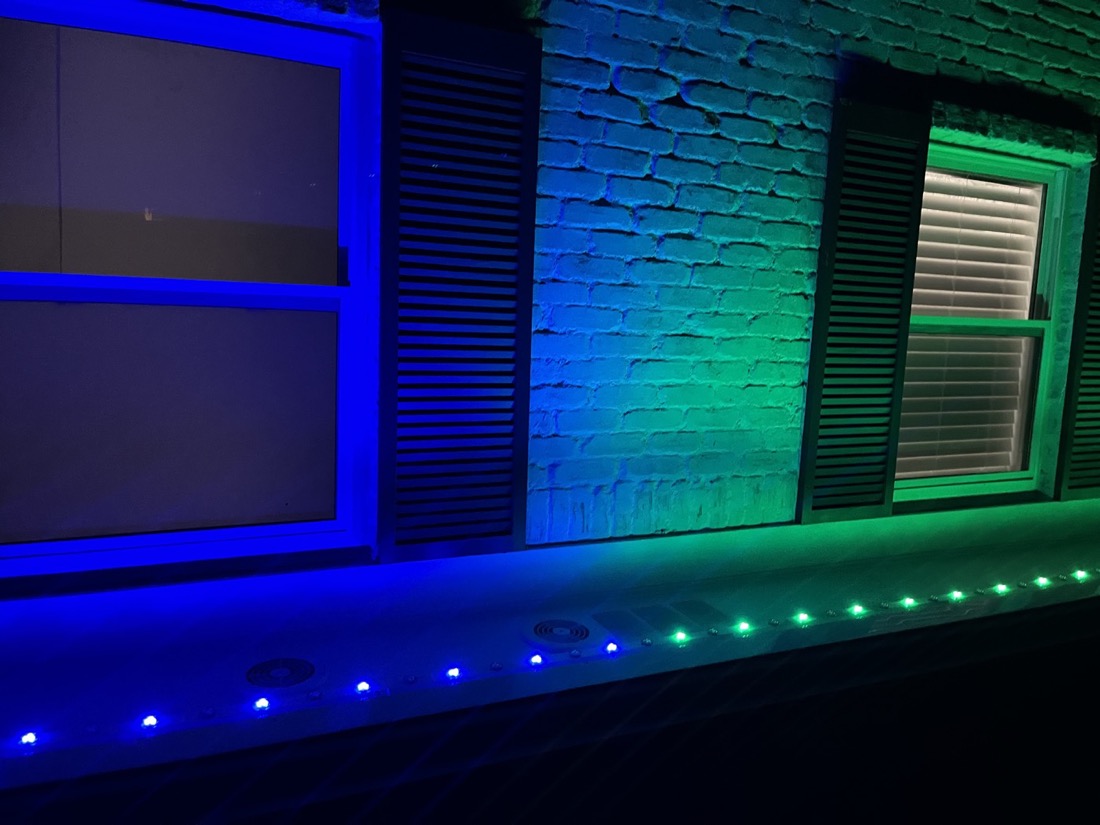 One wall lit in two zones: green on the left, blue on the right, with the eave lights matching.